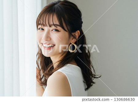 一位微笑著的年輕女子在窗邊微笑的肖像 130686630