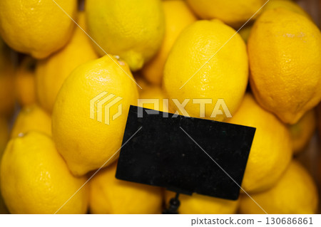 Fresh lemons with price tag on black background. 130686861
