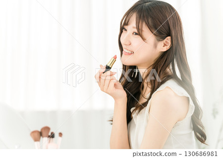 Young Asian woman applying make-up (lipstick, rouge, gloss, lips) Young Asian woman applying make-up (lipstick, rouge, gloss, lips) 130686981