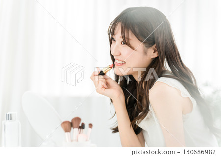 Young Asian woman applying make-up (lipstick, rouge, gloss, lips) Young Asian woman applying make-up (lipstick, rouge, gloss, lips) 130686982