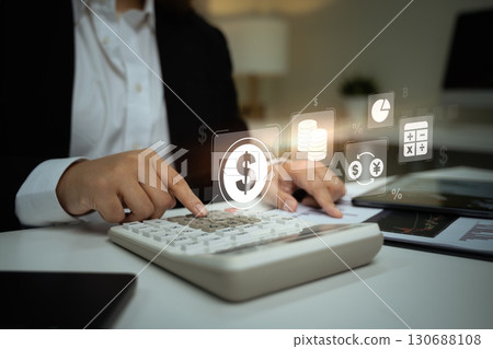 Digital financial concept with currency, graph, and accounting icons over calculator, illustrating fintech and smart banking 130688108