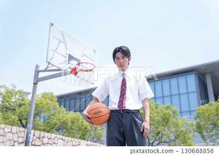 A male high school student standing with a basketball A male high school student standing with a basketball 130688856