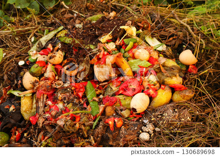 a red compost bin with a pile of food, fruit, and vegetable waste. Compost background. organic waste management sustainable. backyard composting pile 130689698