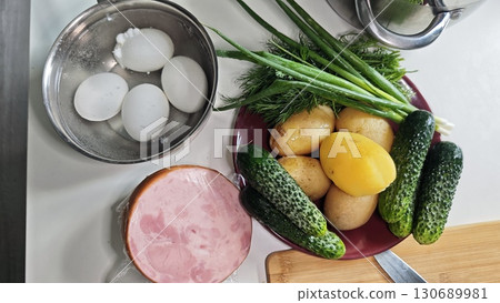 Set of fresh ingredients including cucumbers, eggs, potatoes, ham and herbs prepared for cooking Set of fresh ingredients including cucumbers, eggs, potatoes, ham and herbs prepared for cooking 130689981