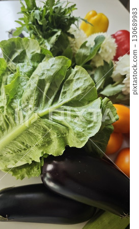 Colorful assortment of fresh vegetables including lettuce, eggplants, peppers and tomatoes 130689983