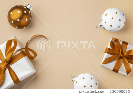 Christmas holiday background, gift boxes with xmas ball decor on light brown background, top view Christmas holiday background, gift boxes with xmas ball decor on light brown background, top view 130690050