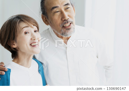 一對老年夫婦從窗邊望向外面 130690147