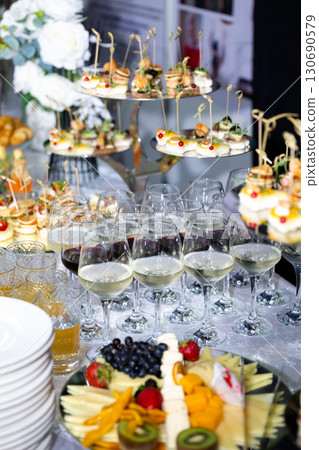 Buffet table with wine glasses, canapes and fruit plate at celebration Buffet table with wine glasses, canapes and fruit plate at celebration 130690579