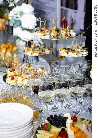 Buffet table with wine glasses, canapes and fruit plate at celebration Buffet table with wine glasses, canapes and fruit plate at celebration 130690580