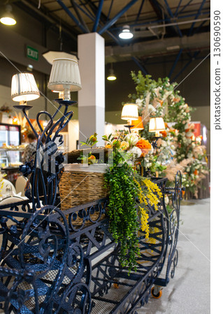 Decorative cart with lamps, flowers and greenery in interior design 130690590