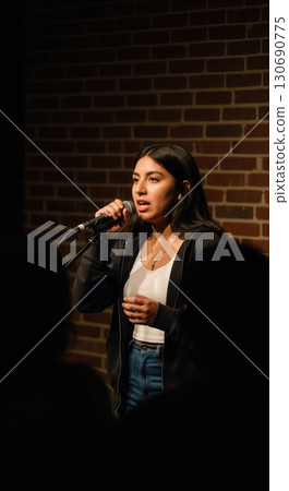 Fierce Poet Performing Spoken Word Poetry Under a Spotlight at an Intimate Open Mic Night 130690775