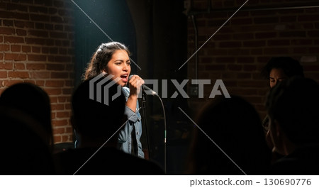Fierce Poet Performing Spoken Word Poetry Under a Spotlight at an Intimate Open Mic Night Fierce Poet Performing Spoken Word Poetry Under a Spotlight at an Intimate Open Mic Night 130690776