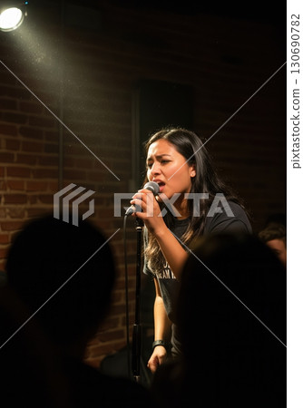 Fierce Poet Performing Spoken Word Poetry Under a Spotlight at an Intimate Open Mic Night Fierce Poet Performing Spoken Word Poetry Under a Spotlight at an Intimate Open Mic Night 130690782