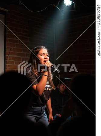 Fierce Poet Performing Spoken Word Poetry Under a Spotlight at an Intimate Open Mic Night 130690784
