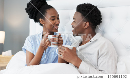 Talking, coffee or happy black couple in bed together to relax on holiday vacation in home, house or hotel bedroom. Tea, morning or African people with love, care and speaking or communication Talking, coffee or happy black couple in bed together to relax on holiday vacation in home, house or hotel bedroom. Tea, morning or African people with love, care and speaking or communication 130691192