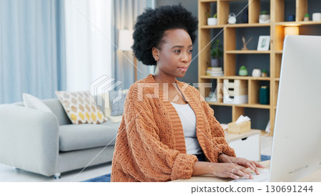 Woman, entrepreneur or student for remote on computer at home. Black, person and concentrate with technology, communication and browsing for research, planning or reading on internet, web or email 130691244