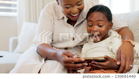 Happy, black family and surprise with phone in home with learning game, video or mom with child on sofa. Wow, face and mother teaching kid in living room on mobile app, online or elearning education 130691440