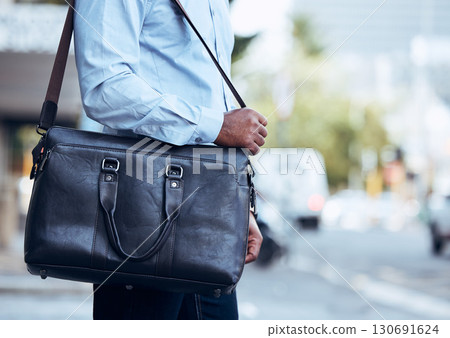 Business man, city and walking with bag, leather briefcase and accessory for travel, work and professional career. Closeup worker carry luggage in street, sidewalk and commute with corporate fashion 130691624