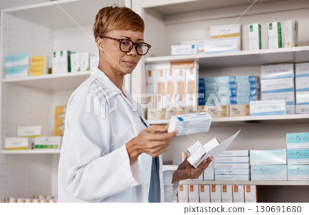 Pharmacist, medicine and healthcare with a woman working and reading information on pills box. Black person in a pharmacy, clinic or shop for pharmaceutical, medical and health service or inventory Pharmacist, medicine and healthcare with a woman working and reading information on pills box. Black person in a pharmacy, clinic or shop for pharmaceutical, medical and health service or inventory 130691680