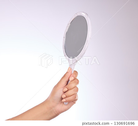 Hand, mirror and beauty with a person in studio on a gray background for a skincare examination. Product, luxury and reflection with a woman holding a tool to apply makeup or cosmetics for wellness Hand, mirror and beauty with a person in studio on a gray background for a skincare examination. Product, luxury and reflection with a woman holding a tool to apply makeup or cosmetics for wellness 130691696