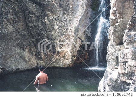 Tourist enjoying refreshing bath at Millomeris waterfall in Cyprus 130691748