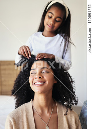 Children, black family and hair with a girl styling her mother in their home for haircare or bonding. Kids, love or style with a female child and woman bonding together over a hairstyle treatment Children, black family and hair with a girl styling her mother in their home for haircare or bonding. Kids, love or style with a female child and woman bonding together over a hairstyle treatment 130691783