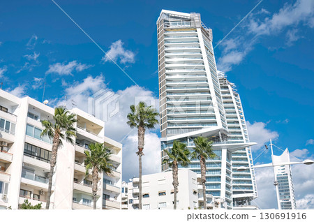 Modern skyscraper towering over traditional buildings in Limassol Cyprus on a sunny day Modern skyscraper towering over traditional buildings in Limassol Cyprus on a sunny day 130691916