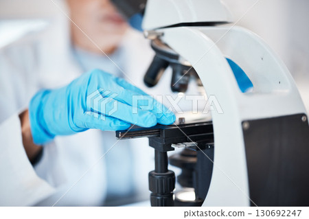 Hands, medical science and microscope in a laboratory for research, analysis and study. Scientist person in lab for futuristic development, innovation and biotechnology with dna or bacteria particle 130692247