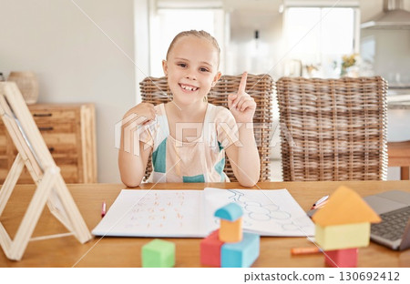 Education, learning and child development with girl drawing and doing homework at a kitchen table at home. Portrait of a happy student smile, enjoying distance learning and educational art project 130692412