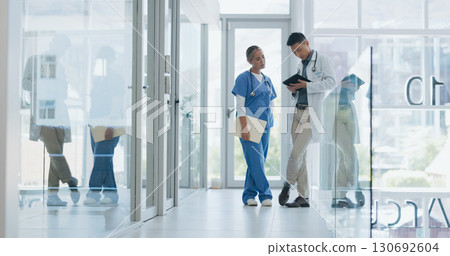 Doctors, partnership and hospital with tablet, talk and ideas in meeting, discussion or strategy with planning. Medical staff, team and analysis for wellness, consulting or feedback in clinic hallway Doctors, partnership and hospital with tablet, talk and ideas in meeting, discussion or strategy with planning. Medical staff, team and analysis for wellness, consulting or feedback in clinic hallway 130692604