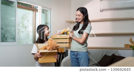 Family Bonding. Mother and daughter unpacking boxes in new home. Family Bonding. Mother and daughter unpacking boxes in new home. 130692685