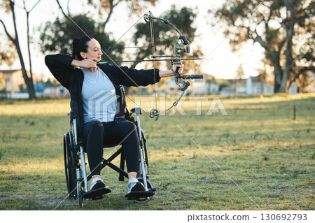 Outdoor archery, disabled woman in wheelchair and challenge for active sports lifestyle in Canada. Person with disability in a park, fitness activity to exercise arms with bow and arrow for hobby Outdoor archery, disabled woman in wheelchair and challenge for active sports lifestyle in Canada. Person with disability in a park, fitness activity to exercise arms with bow and arrow for hobby 130692793