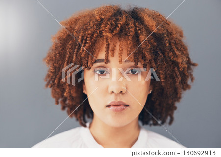 Beauty, afro and black woman face or activist for empowerment and looking serious, confident and proud. Portrait, head and African American female with curly hair isolated in gray background Beauty, afro and black woman face or activist for empowerment and looking serious, confident and proud. Portrait, head and African American female with curly hair isolated in gray background 130692913