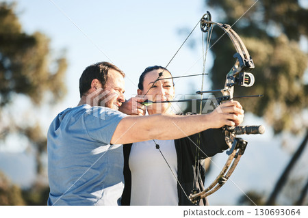 Archery, shooting range and sports training to aim with a woman and man outdoor for target practice. Archer and athlete person with focus on field for competition or game to shoot arrow for action Archery, shooting range and sports training to aim with a woman and man outdoor for target practice. Archer and athlete person with focus on field for competition or game to shoot arrow for action 130693064