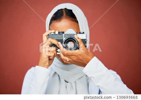 Photography, muslim woman taking picture with camera and mockup with smile isolated on red background. Creative professional lifestyle photographer in hijab, hobby or career taking photo in studio. Photography, muslim woman taking picture with camera and mockup with smile isolated on red background. Creative professional lifestyle photographer in hijab, hobby or career taking photo in studio. 130693668