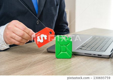 Businessman looking at green fuel price tag. Energy costs, fuel market, transition to eco transport and sustainability challenges. Good for topics of policy, innovation and economy. Businessman looking at green fuel price tag. Energy costs, fuel market, transition to eco transport and sustainability challenges. Good for topics of policy, innovation and economy. 130693759