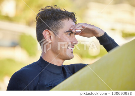 Surfer man, beach and looking with smile for waves, excited and hand by eyes for safety in morning sunshine. Ocean athlete, surfboard or focus for fitness, sports and tropical adventure for workout 130693988