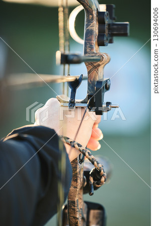 Sports archer, hands and bow and arrow training for archery competition, athlete challenge or girl field practice. Shooting, talent and competitive woman focus on precision, aim or outdoor objective 130694006