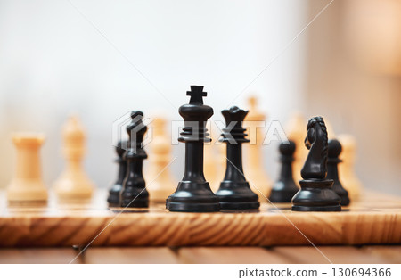 Chess, board games and black pieces on wooden table in focus with queen protecting the king in strategic match. Vintage game in problem solving for skilled players in tactics or strategy on mockup 130694366