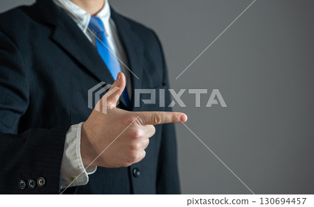 Businessman points his finger. To attract attention. To confidently show what to pay attention to. Space for text, copy space, leadership concept, business direction, decision making. 130694457