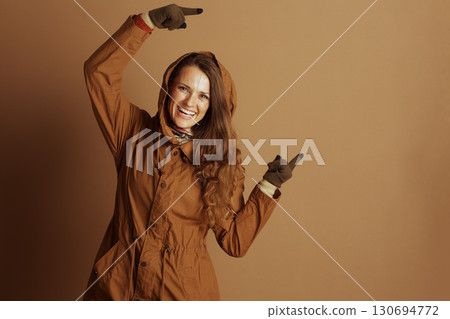 Joyful Woman Pointing Upwards with Both Hands 130694772