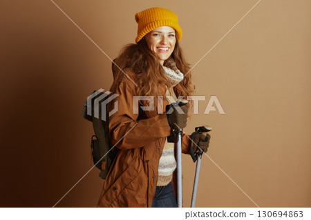 Adventurous Woman with Backpack and Trekking Poles Adventurous Woman with Backpack and Trekking Poles 130694863