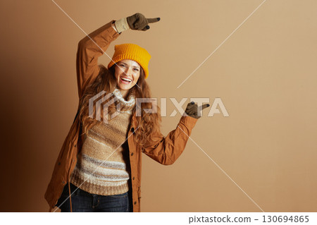 Energetic Woman in Winter Fashion Pointing Energetic Woman in Winter Fashion Pointing 130694865