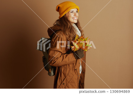 Autumn Joy: Woman with Leaves and Backpack 130694869