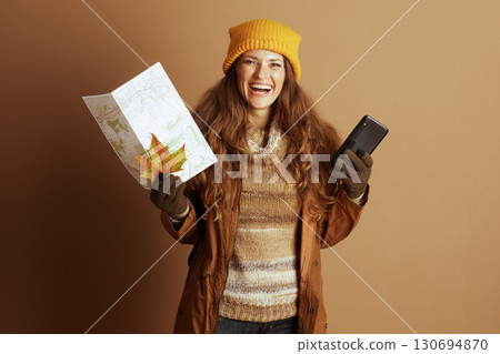 Cheerful Autumn Traveler with Map and Phone 130694870