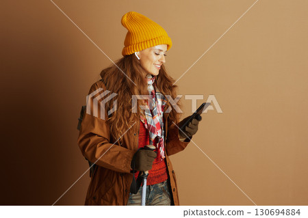 Woman Navigating Outdoors with Phone and Earbuds 130694884