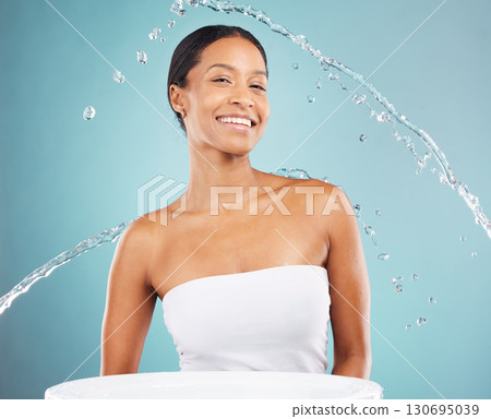 Water splash, bathroom and portrait of black woman on blue background, studio and beauty cosmetics. Face of happy female model, shower and cleaning for healthy skincare, wellness and facial aesthetic Water splash, bathroom and portrait of black woman on blue background, studio and beauty cosmetics. Face of happy female model, shower and cleaning for healthy skincare, wellness and facial aesthetic 130695039