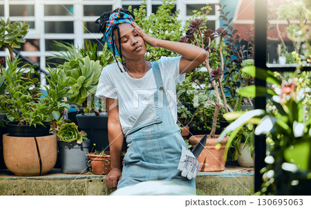 Tired, gardener or black woman with headache, stress or burnout after cleaning dirty plants or flowers. Gardening, fatigue or exhausted girl resting after working on environmental maintenance job 130695063