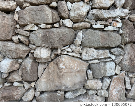 Stone wall photo, textured background. Close-up of a rustic stone wall. 130695072