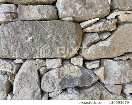 Stone wall photo, textured background. Close-up of a rustic stone wall. Stone wall photo, textured background. Close-up of a rustic stone wall. 130695079